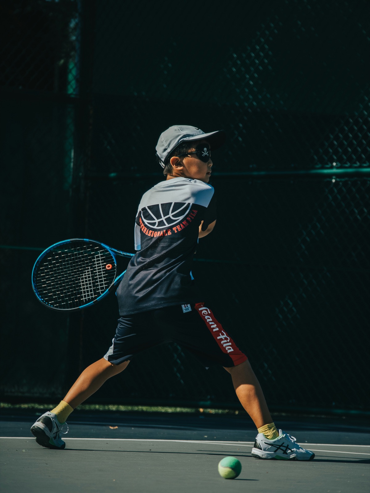 A junior player mid-backhand