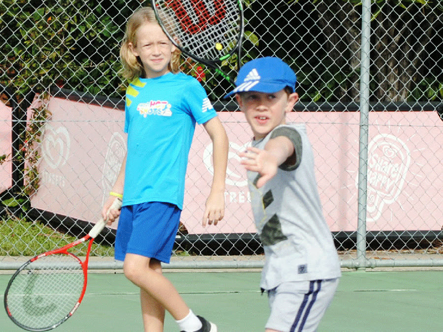 Two junior players rallying on court